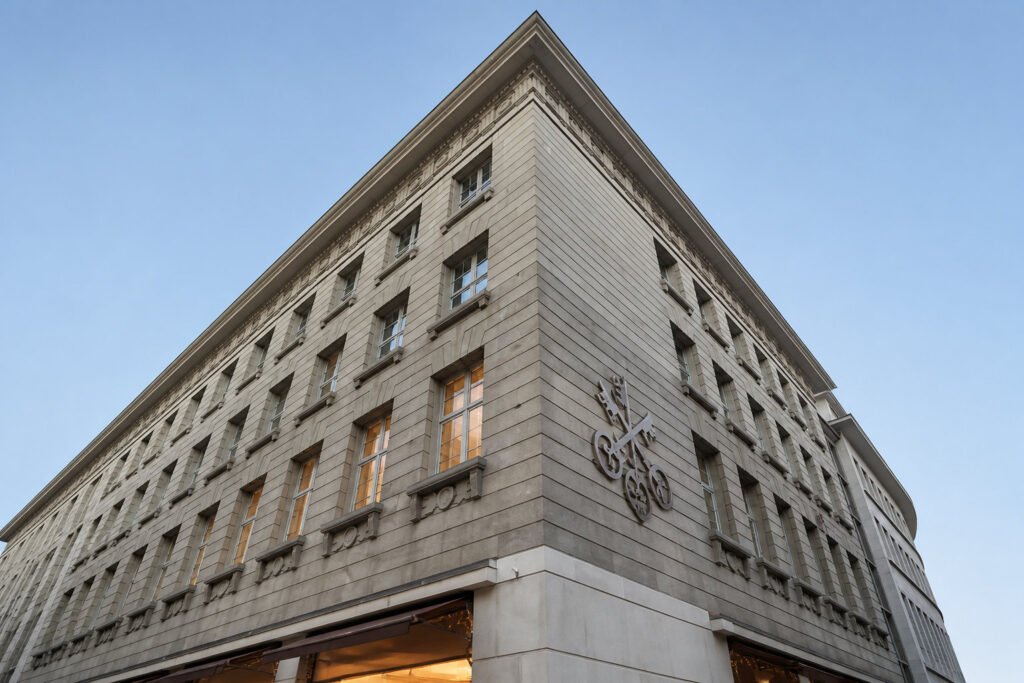 Vue en contre-plongée du bâtiment du Credit Suisse avec son emblème de clés croisées sous un ciel bleu.